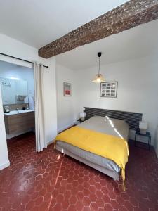 een slaapkamer met een bed met een gele deken bij Chez Sam et L'As du Forum, Centre ville in Arles