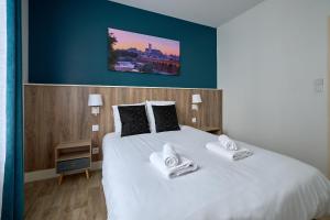 ein Schlafzimmer mit einem großen weißen Bett mit zwei Kissen in der Unterkunft Le Faidherbe style Appart' Hôtel - WIFI gratuit - Parking Gratuit Calme et Lumineux in Nevers