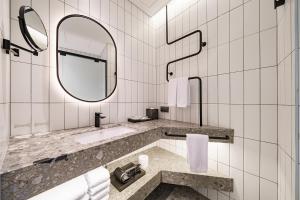 a bathroom with a sink and a mirror at Take Hotel Seoul Gwangmyeong in Gwangmyeong