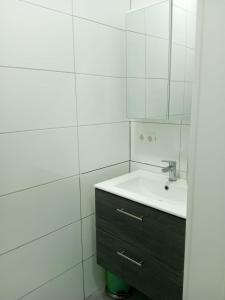 ein weißes Badezimmer mit einem Waschbecken und einem Spiegel in der Unterkunft Nina Zimmer in Heilbronn Zentrum in Heilbronn