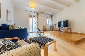 uma sala de estar com um sofá azul e uma televisão em GROOOVY Dúplex amb Terrassa em Tarragona
