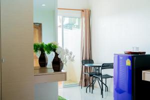 un soggiorno con tavolo, sedie e vaso fiorito di The Infinity Suite Chiangrai a Chiang Rai