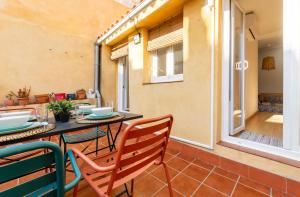 a patio with a table and chairs and a window at GROOOVY Dúplex amb Terrassa in Tarragona
