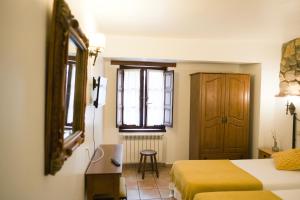 um quarto de hotel com duas camas e uma janela em Posada la Estela de Barros em Los Corrales de Buelna