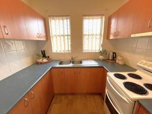 a kitchen with a sink and a stove at Beautifully Styled 3 Bedroom Apartment in South Hedland