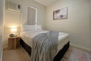 ein Schlafzimmer mit einem Bett in einem weißen Zimmer in der Unterkunft Beautifully Styled 3 Bedroom Apartment in South Hedland