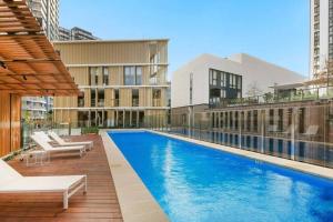 uma piscina com cadeiras e um edifício em CBD Haymarket 2B1B Apt w shared pool, walk to Chinatown em Sydney
