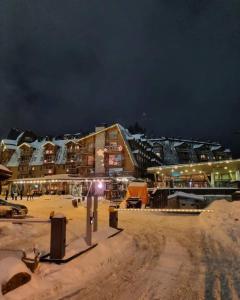 Un grupo de edificios en una playa por la noche. en Private Apartment Lora - Aparthotel Vučko, en Jahorina