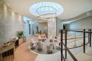 a lobby with a staircase and a chandelier at NH Collection Palazzo Verona in Verona