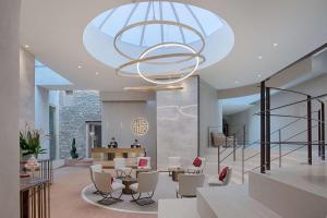 a lobby with a large chandelier and tables and chairs at NH Collection Palazzo Verona in Verona