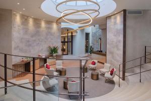 a lobby with a chandelier and white chairs at NH Collection Palazzo Verona in Verona