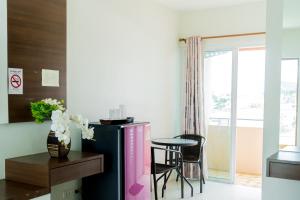 a living room with a table and a refrigerator at The Infinity Suite Chiangrai in Chiang Rai