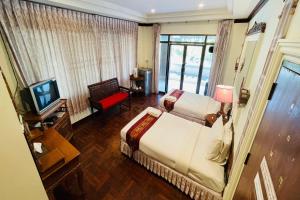 una habitación de hotel con una cama y un televisor en Baan Rim Kwai Paerimnam Resort, en Kanchanaburi
