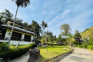 een huis met een boomstronk ervoor bij Baan Rim Kwai Paerimnam Resort in Kanchanaburi