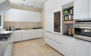 a white kitchen with white cabinets and appliances at Luxury Vacation Villa 13 in Pointe Milou