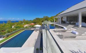 a house with a swimming pool next to a house at Luxury Vacation Villa 13 in Pointe Milou