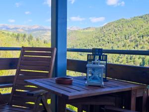 a wooden table on a porch with a view of mountains at Can Geneta in Molló
