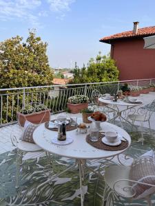 a patio with tables and chairs on a balcony at Villa House and Garden B&B in Montichiari