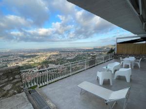 balcón con mesas y sillas y vistas a la ciudad en Super panoramic new apartment in Casertavecchia en Caserta