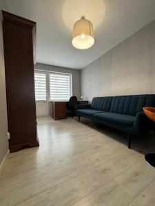 a living room with a blue couch and a table at Dārzu ielas apartamenti in Rēzekne +1 photo