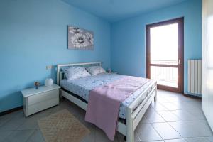 una camera blu con un letto e una finestra di il Geco a Sulzano