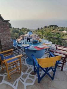 Vourliótai的住宿－Grammatikis house，海景露台上的蓝色桌椅