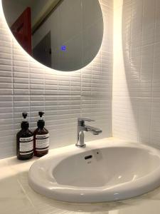 a white sink with a mirror and two bottles of soap at Priew Wan Guesthouse in Patong Beach