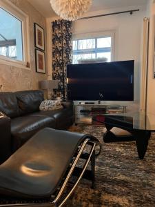 ein Wohnzimmer mit einem Sofa und einem Flachbild-TV in der Unterkunft LOU PANTAI in Levens