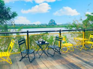 stół i krzesła na tarasie z widokiem na rzekę w obiekcie Trang An Cozy House w mieście Diếm Xá
