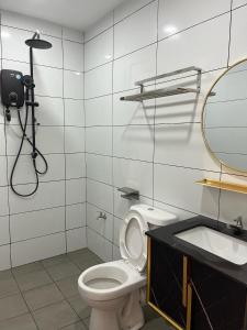 a bathroom with a toilet and a sink and a mirror at Halo Hotel in Semporna