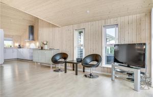 uma sala de estar com 2 cadeiras e uma televisão de ecrã plano em Beautiful Home In Slagelse With Kitchen em Venemose