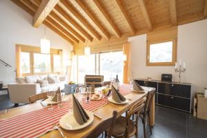 a dining room with a long table with chairs at Chasa Capricornin in Scuol