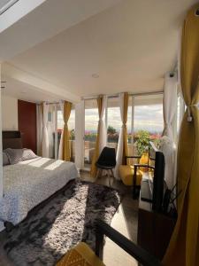 ein Schlafzimmer mit einem Bett und einem großen Fenster in der Unterkunft ¡Intimo, pequeño, confortable, mejor que hotel! in Mexiko-Stadt