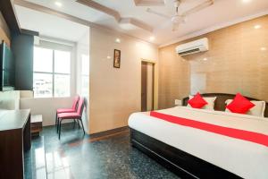 1 dormitorio con 1 cama grande con almohadas rojas en HOTEL TEJASRI RESIDENCY en Vijayawāda
