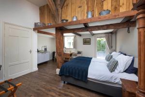 a bedroom with a large bed with wooden beams at Hofstede de Rieke Smit in Wilsum
