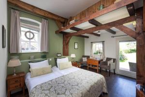 Schlafzimmer mit einem Bett, einem Schreibtisch und einem Fenster in der Unterkunft Hofstede de Rieke Smit in Wilsum