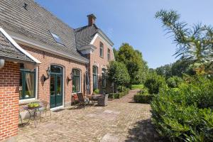 a brick house with a patio in front of it at Hofstede de Rieke Smit in Wilsum
