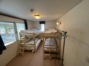 a room with three bunk beds and a window at TaoTechHOUSE in Hakuba
