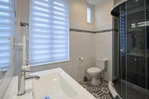 La salle de bains est pourvue d'un lavabo, de toilettes et d'une fenêtre. dans l'établissement Le Faidherbe style Appart' Hôtel - WIFI gratuit - Parking Gratuit Calme et Lumineux, à Nevers