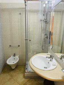 een badkamer met een wastafel, een douche en een toilet bij B&B Marina Sleep And Ship in Rodi Garganico