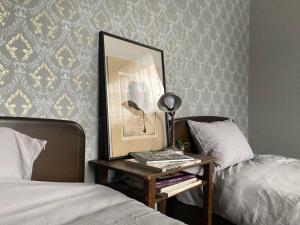 a table with a picture and a lamp next to two beds at Maison Petit Lapin メゾンプチラパン in Karuizawa