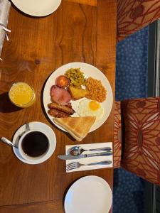 a table with a plate of breakfast food and a cup of coffee at Leaking Well, Dunhampton in Stourport