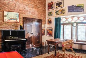 a living room with a piano and a table at Relais Cascina San Martino in San Marzano Oliveto