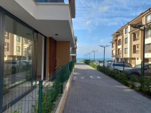 een stoep naast een gebouw met geparkeerde auto's bij Сарафово Лукс Тераса Първа Линия in Sarafovo