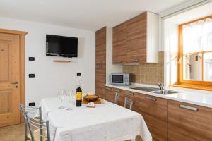 a kitchen with a table with a bottle of wine at Cesa Raggio di Sole Bilocale in Livinallongo del Col di Lana