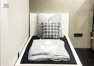 a bed with a black and white blanket and a pillow at Luxuriöse Villa am Wiesensee in Pottum