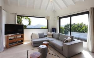 uma sala de estar com um sofá e uma televisão de ecrã plano em Luxury Vacation Villa 14 em Anse des Cayes