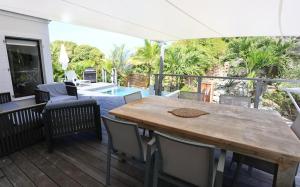 a patio with a wooden table and chairs and a pool at Luxury Vacation Villa 14 in Anse des Cayes