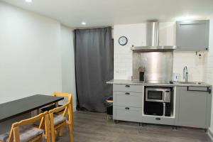 a kitchen with a counter and a table and a microwave at Charmante ancienne grange in Villevaudé
