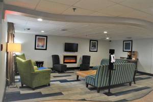 a waiting room with chairs and a fireplace at Best Western Owego Inn in Owego